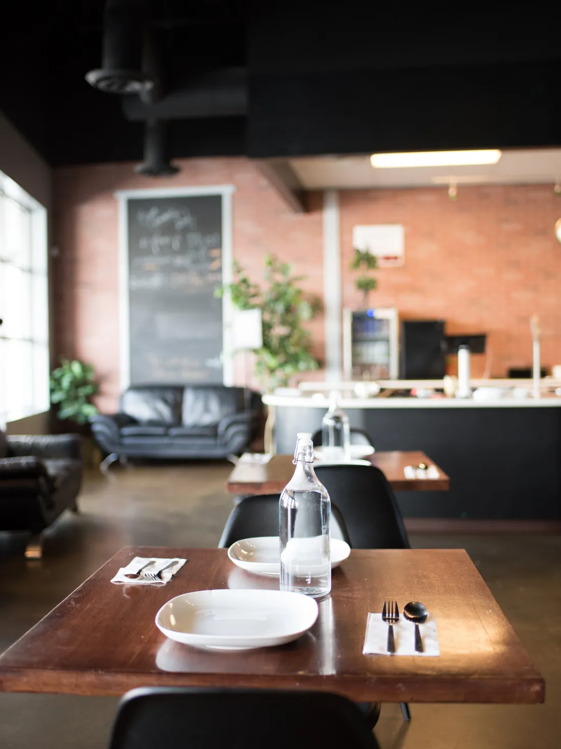 Pique Thai dining room with brick wall and set tables