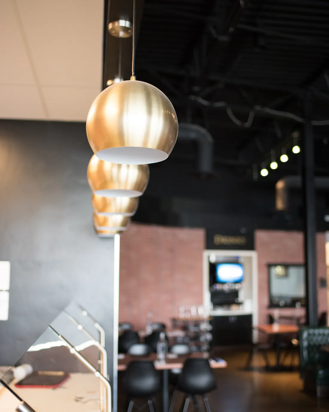 Brass pendant lights above the counter at Pique Thai